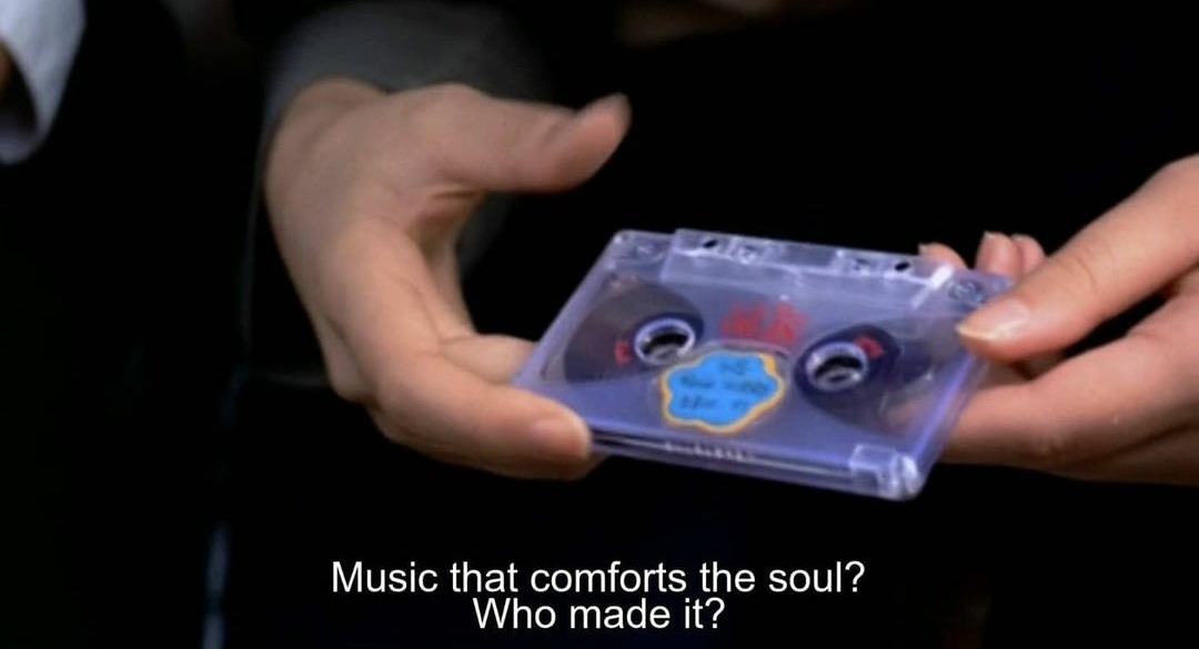 Imagem de um par de mãos segurando uma fita cassete, na legenda em inglês está escrito &ldquo;Música que conforta a alma? Quem fez isso?&rdquo; em tradução livre