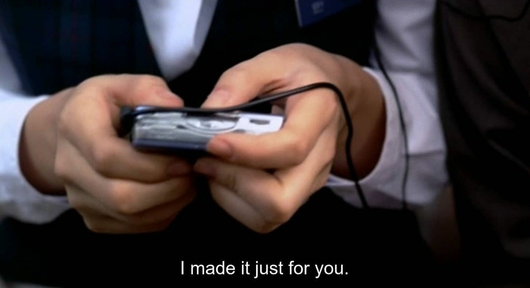 Imagem de um par de mãos segurando um tocador de fita cassete, na legenda em inglês está escrito &ldquo;Eu fiz pra você&rdquo; em tradução livre