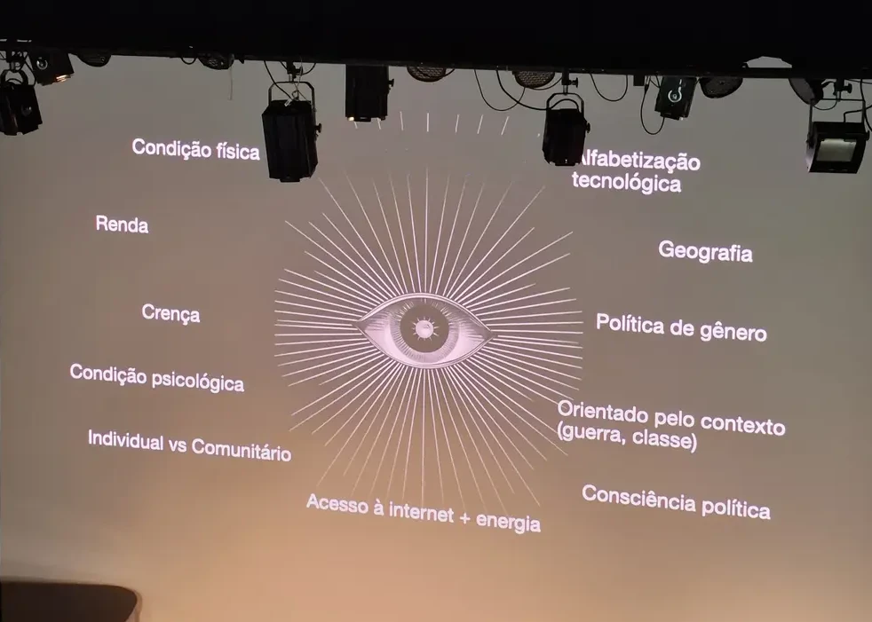 Slide de uma palestra sobre descolonização do mito CypherPunk que rolou no auditório, mostra um desenho de um olho com diversas palavras ao redor