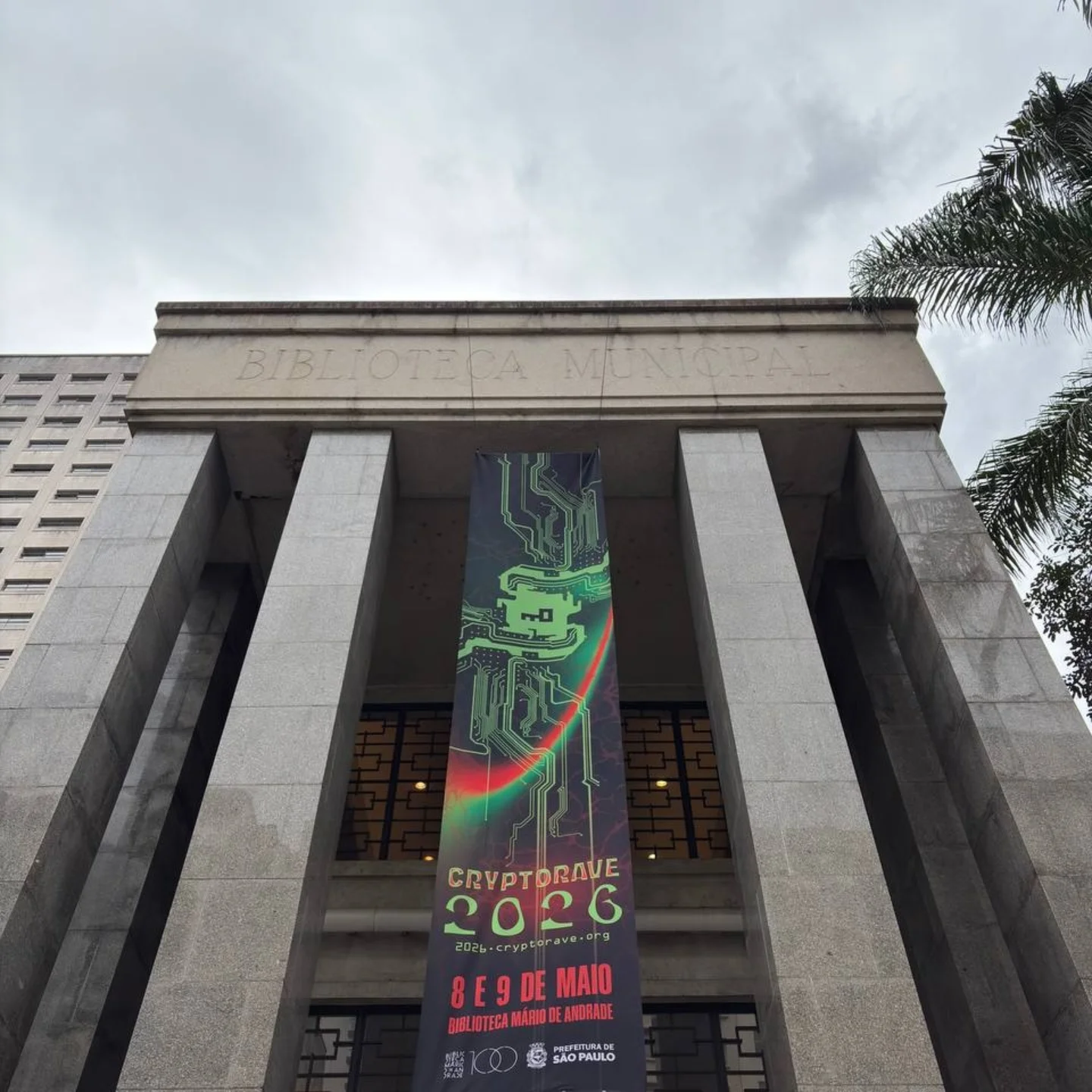 Imagem da entrada da biblioteca Mario de Andrade, com o banner da Cryptorave estendido