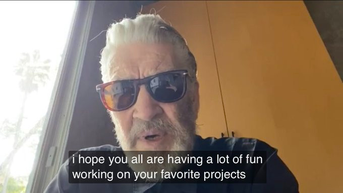 David Lynch barbudo usando um ôculos escuro, com a legenda em inglês &ldquo;Eu espero que vocês se divirtam bastante trabalhando nos seus projetos favoritos&rdquo;