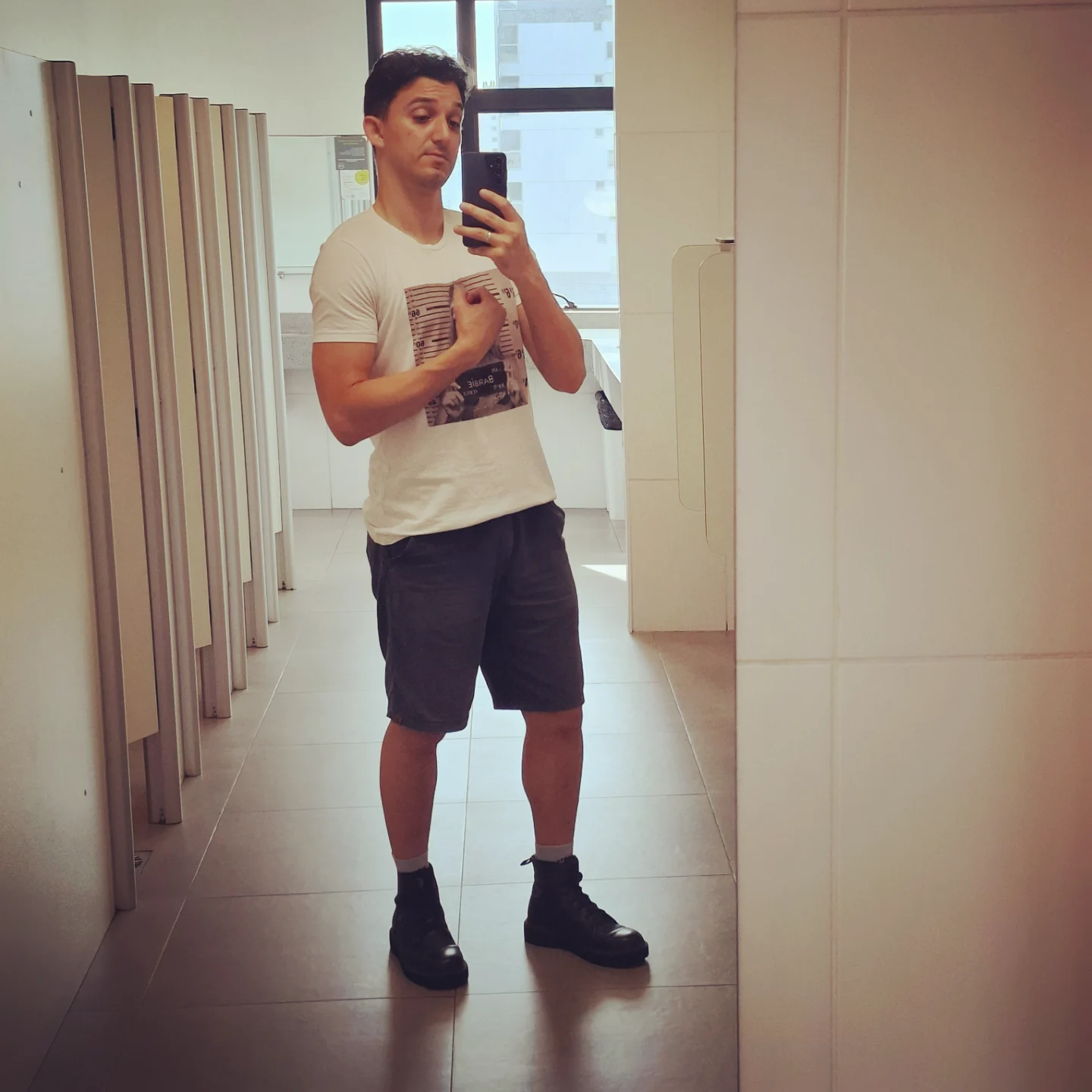 Uma selfie minha de corpo inteiro num banheiro, mostrando o braço