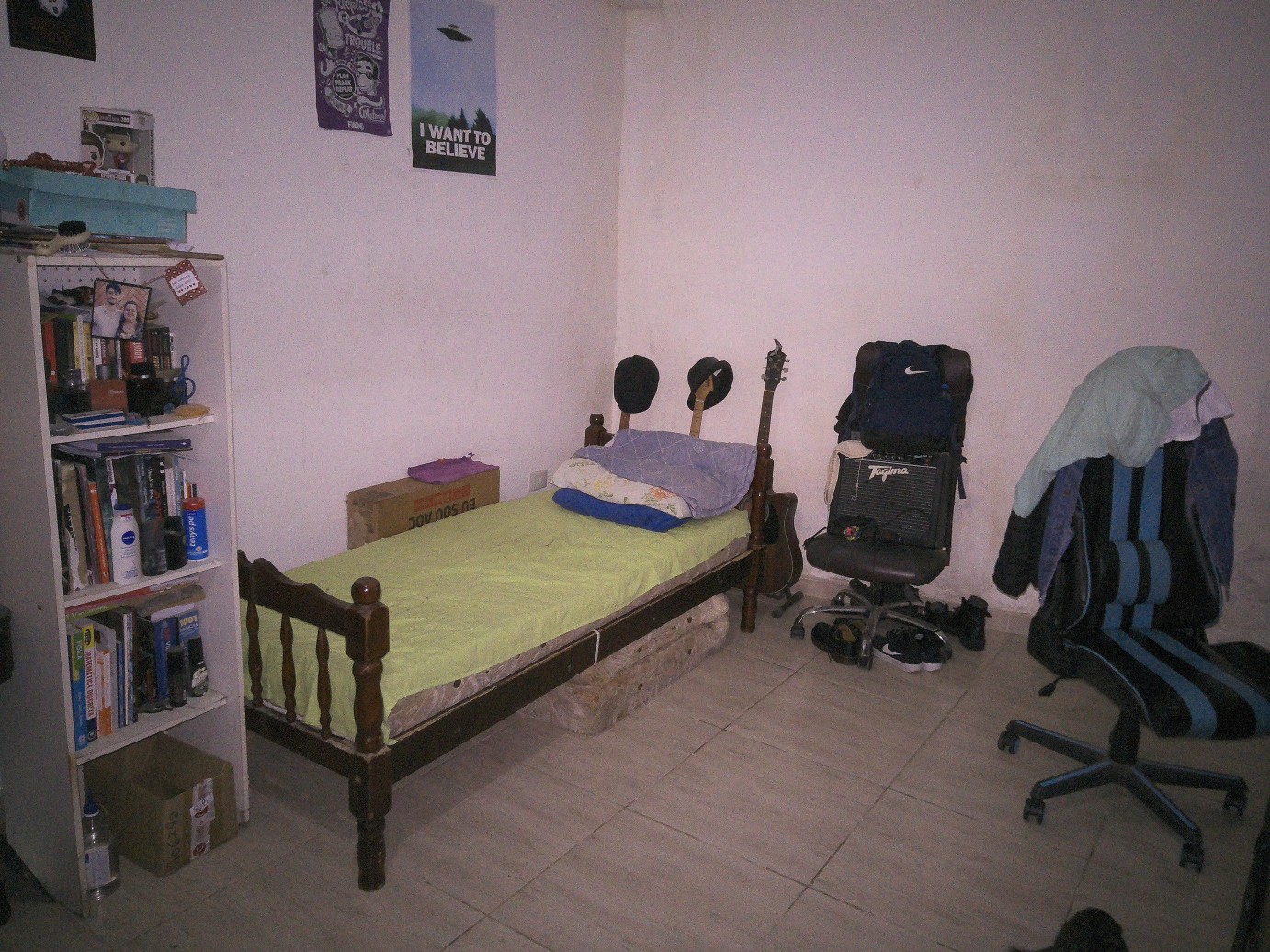 &ldquo;Foto do meu quarto na casa antiga, mostra ao centro da imagem minha cama com meus instrumentos musicais atrás e meu amplificador, a esquerda minha estante de livros e a direita uma cadeira gamer.&rdquo;