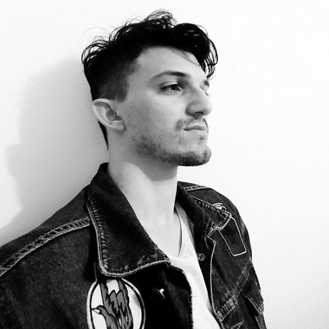 Minha foto de perfil, em preto e branco, um homem narigudo e queixudo de cabelo preto curto, de jaqueta jeans.